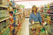 žena s košarom između polica