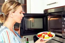 žena stavlja hranu u mikrovalnu